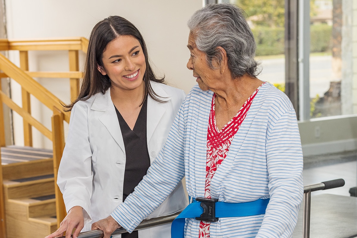 Female physical therapist helping woman