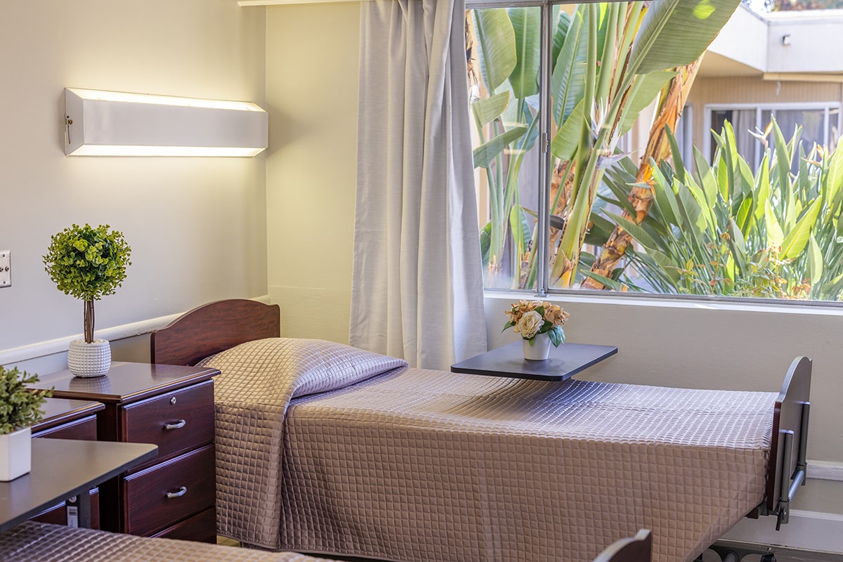 Close up of resident room window with palm trees outside