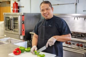 Chef chopping peppers in kitchen