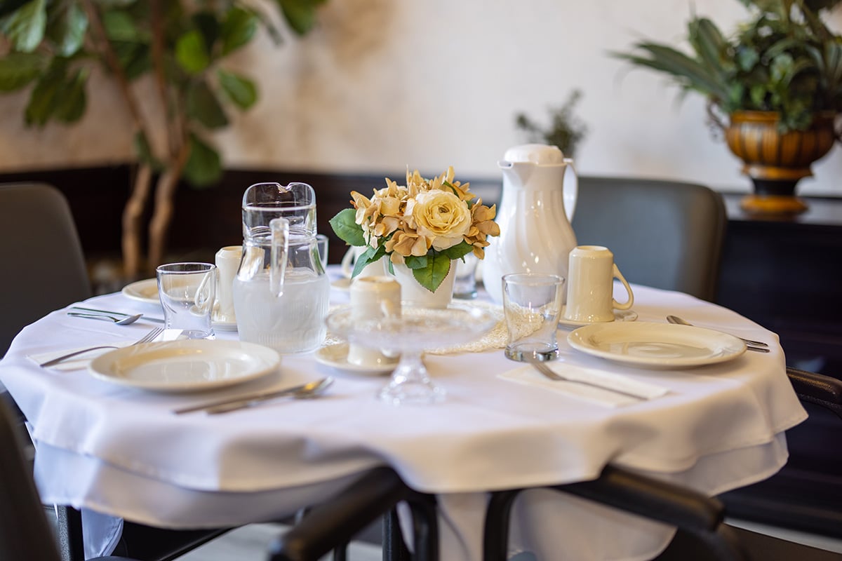 Dining table with white place settings and flower centerpiece